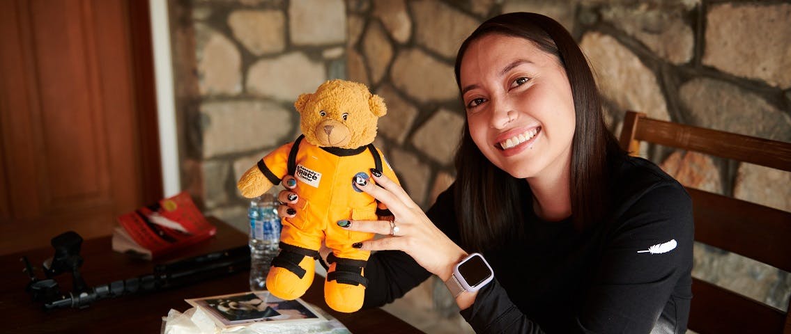 Katya Echazarreta (right) holds up a teddy bear in an orange spacesuit